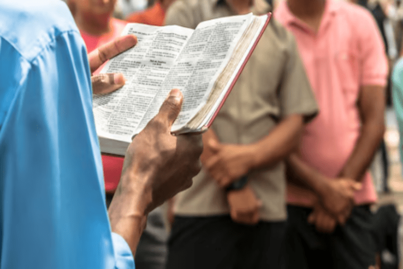 fim dos tempos segundo a biblia, homem lendo a biblia para multidão